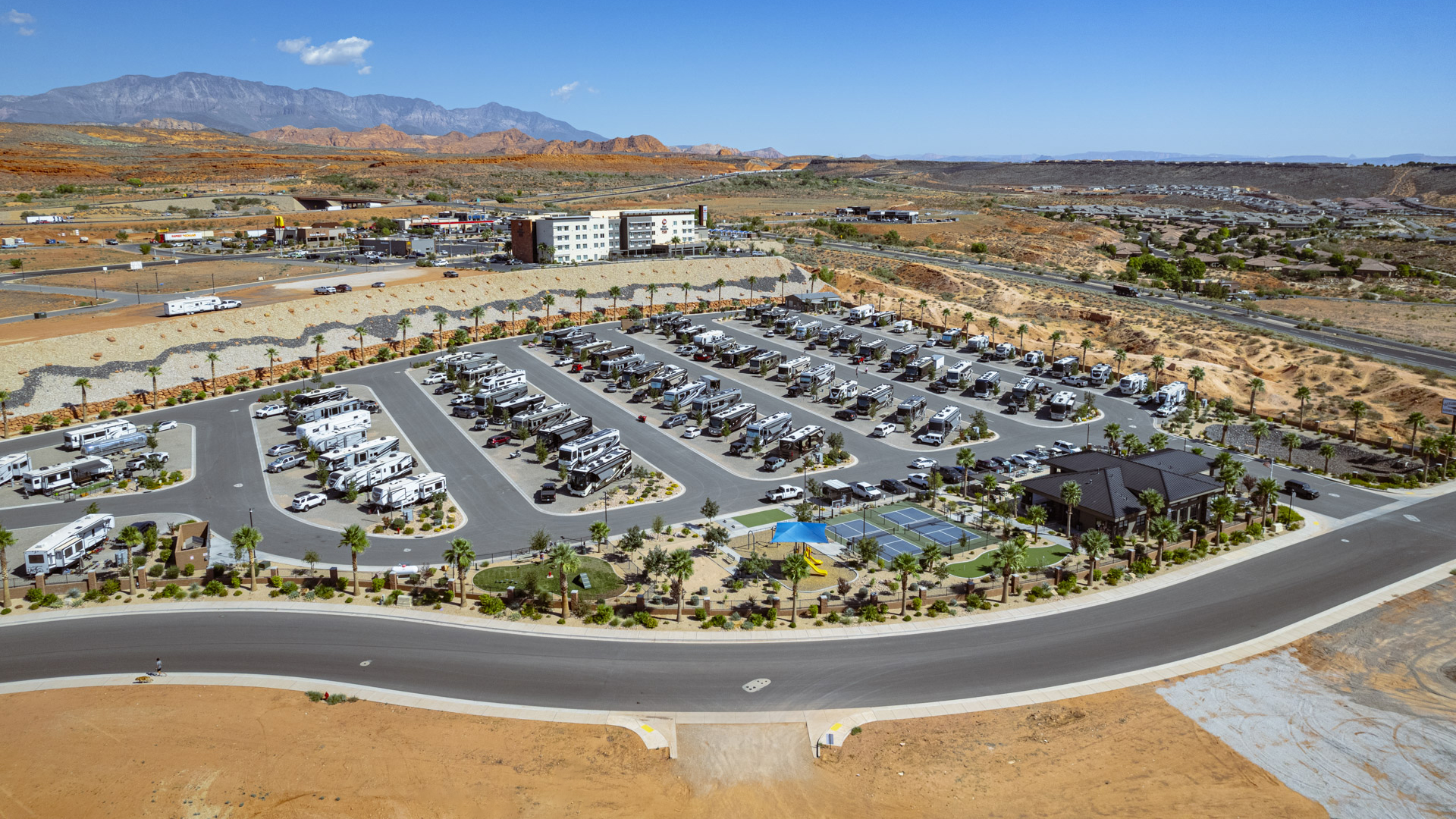 Aerial view of Settlers Point RV Park in Utah with RVs, recreational areas, and mountains in the background