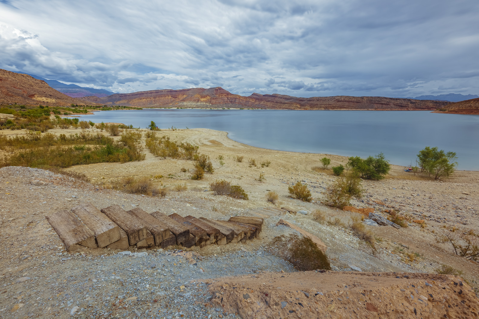 Serene view of Quail Creek State Park’s pristine lake surrounded by rugged Southern Utah landscapes near Settlers Point Luxury RV Resort