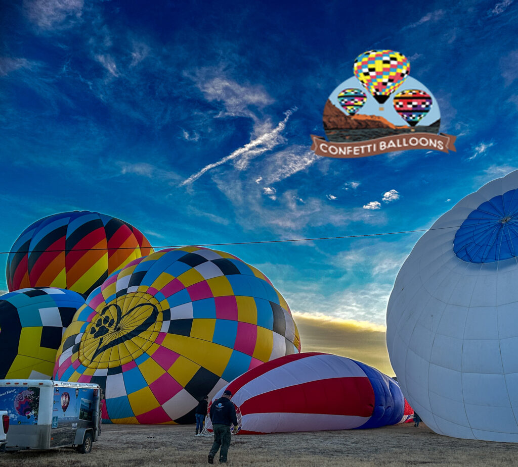 Colorful hot air balloons inflating at sunrise near Settlers Point RV Park in Utah, creating a vibrant and scenic outdoor adventure experience.